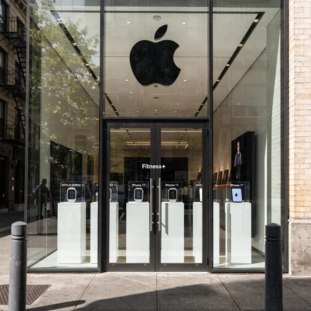 A realistic photo of an Apple store showcasing Apple Fitness+ services, Apple Watch Series 11, iPhone 17, and new Apple product displays.