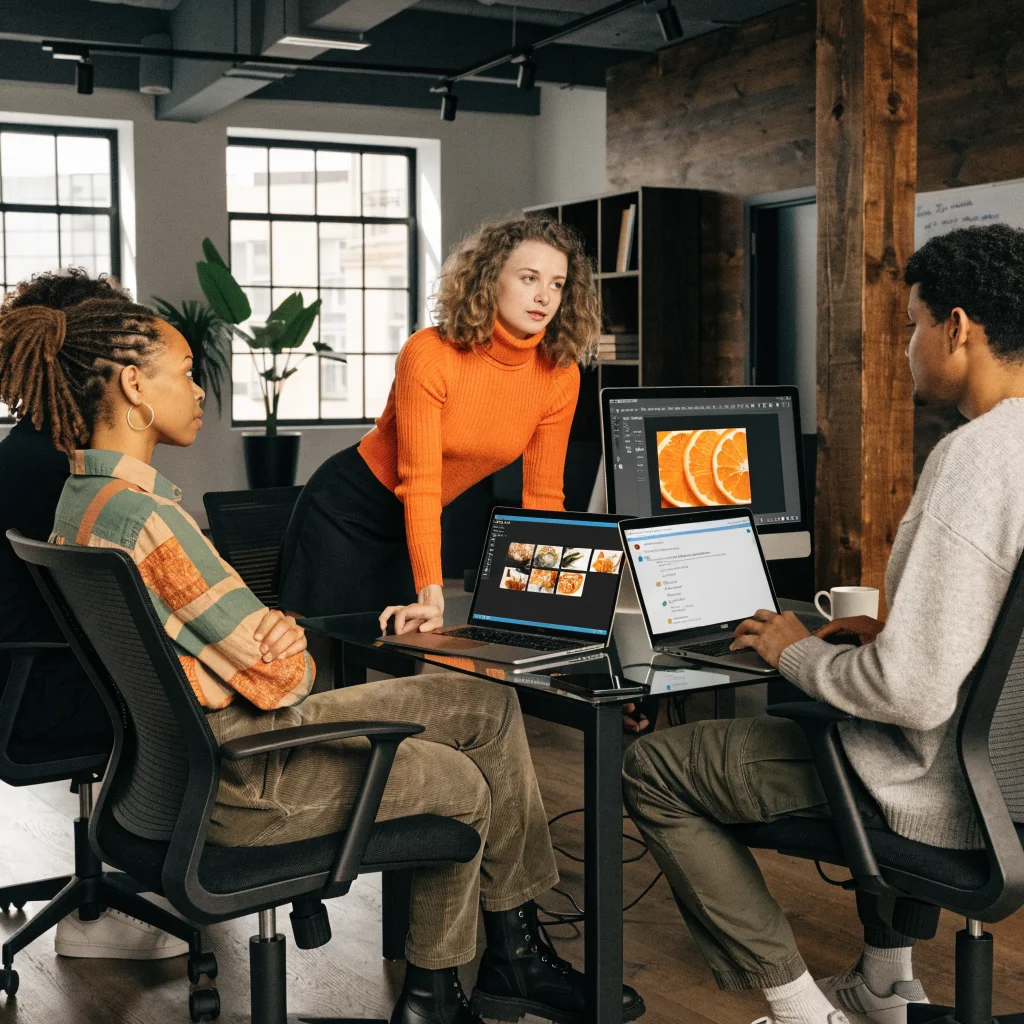 A team of professionals collaborating on Adobe Creative Cloud and Slack integration for image management and project editing in a modern office environment.