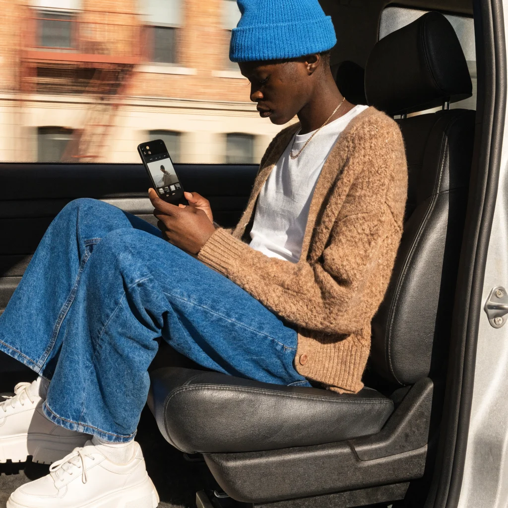 A realistic photo of a person using an Android smartphone with the Android Motion Assist feature active, showing calm during motion in a moving vehicle.