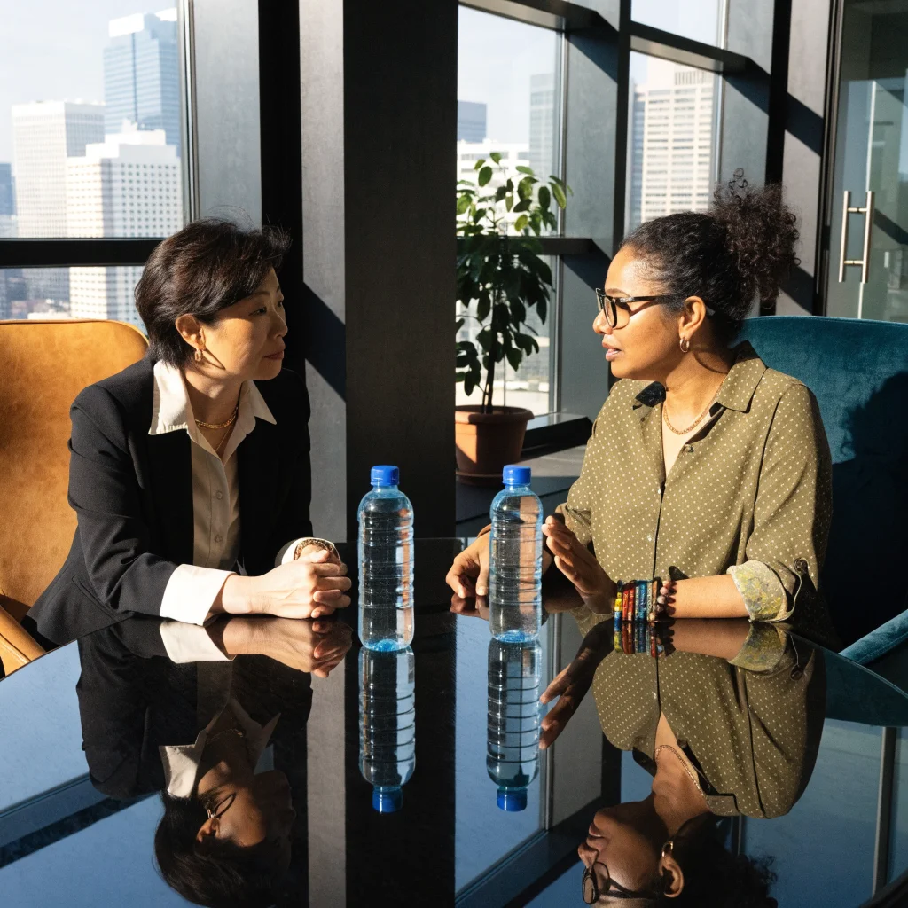 A professional photo of Xbox executives Helen Chiang and Asha Sharma discussing the 2023 Xbox leadership changes and strategic brand reset at Microsoft headquarters.