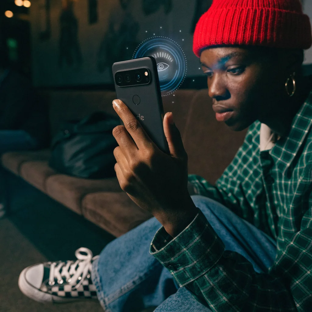 A person unlocking a Google Pixel phone using Face Active Illumination face unlock in a dark room with visible biometric scanning effects.