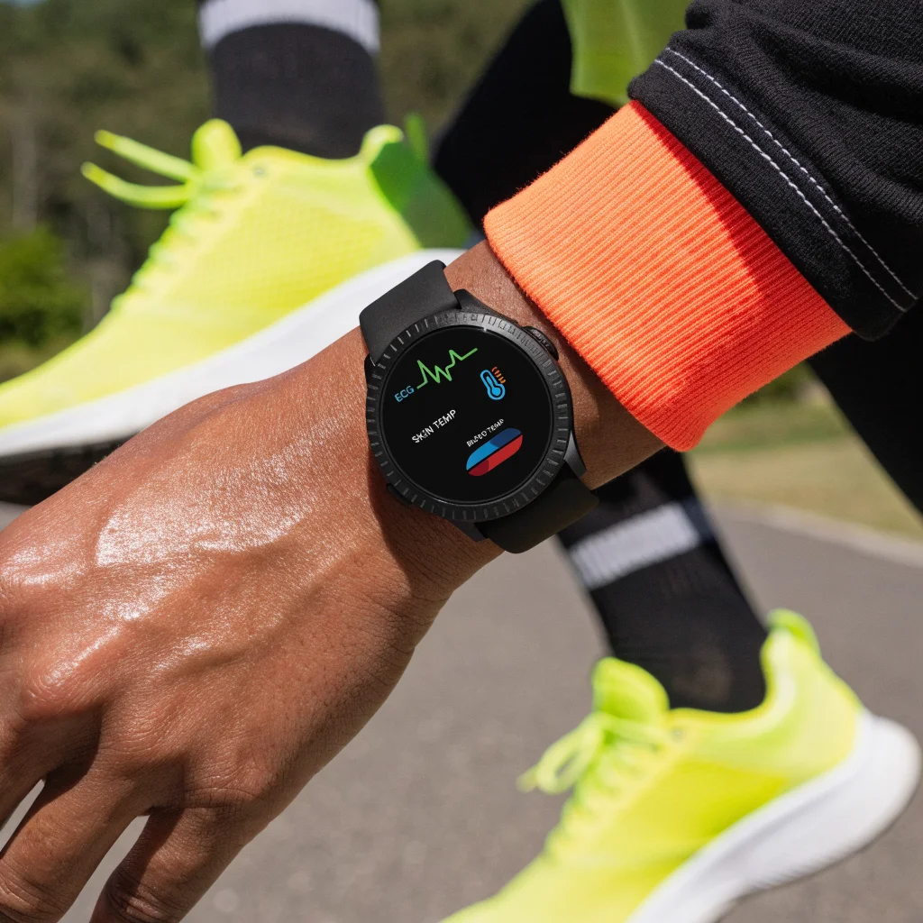 A close-up photo of the Fitbit Edge smartwatch displaying ECG, skin temperature, and blood oxygen sensors on a person's wrist during a fitness workout.
